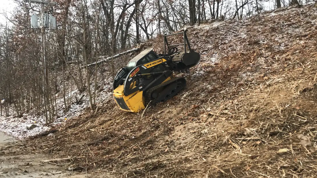 Mulching a steep bank near power lines.