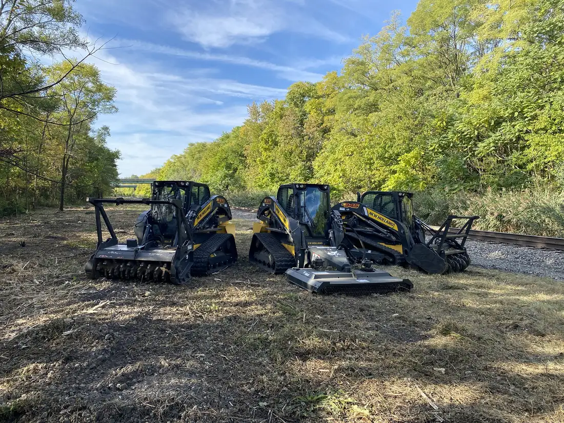 Three forestry mulchers on a rail corridor