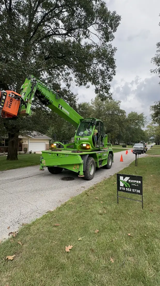 Crane set up on a residential street, cones out.
