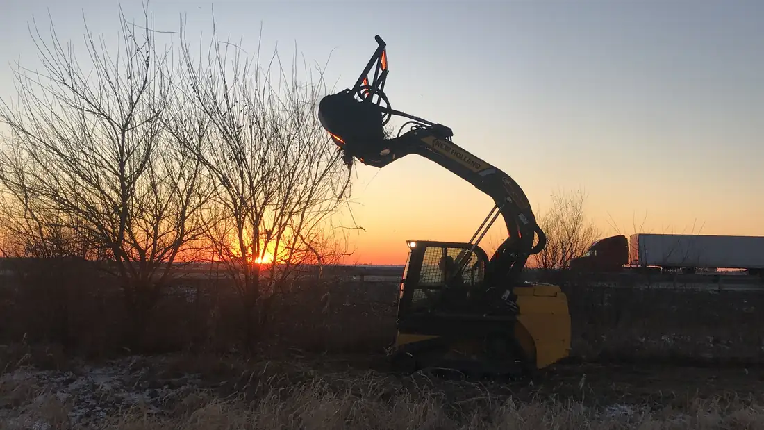 Clearing roadside brush at sundown.